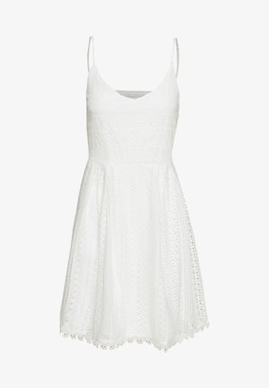 Bílá bezrukávová šaty s výstřihem do V, s ornamentální texturou a rozšířenou sukní. Lem s vlnkovým designem.