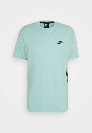 T-shirt in cotone verde menta con logo Nike nero sul petto e etichetta laterale. Collo rotondo e maniche corte. Texture morbida.