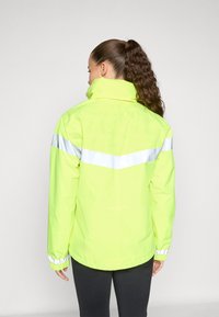 High-visibility yellow waterproof jacket with reflective white stripes, standing collar, and elastic cuffs, viewed from the back.
