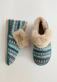 Zapatillas de interior de punto con un patrón azul y verde, que cuentan con un puño de piel sintética beige y una suela texturizada y acolchada.