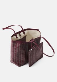 Borsa a tracolla color marrone con esterno decorato e interno beige, dotata di due manici e una pochette con zip staccabile. Texture liscia e forma strutturata.