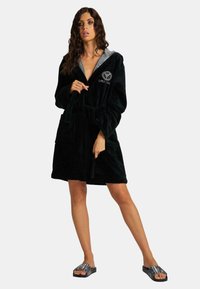 Zwarte, plush microfiber badjas met een twee-kleurige kap, voorzien van een strikceintuur en zijzakken. Versierd met geborduurde tekst op de borst.