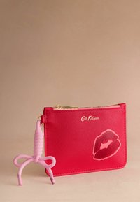 Rdeča denarnica na zadrgo iz teksturiranega materiala, z vzorcem ustnic, z zlatim okovjem in rožnatim silikonskim detajlom ključavnice.