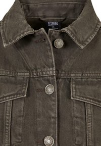 Olive-green denim jacket with two front pockets, silver buttons, and a collared neckline. Textured fabric with visible stitching details.