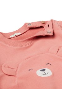 Felpa rosa per neonati con bottoni a pressione sul collo e un'applicazione di una faccia di orsetto sorridente con orecchie sulla parte anteriore.