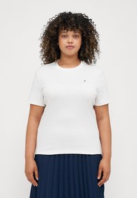 White cotton t-shirt with a crew neck, short sleeves, and a small logo accent on the chest. Smooth texture and regular fit.