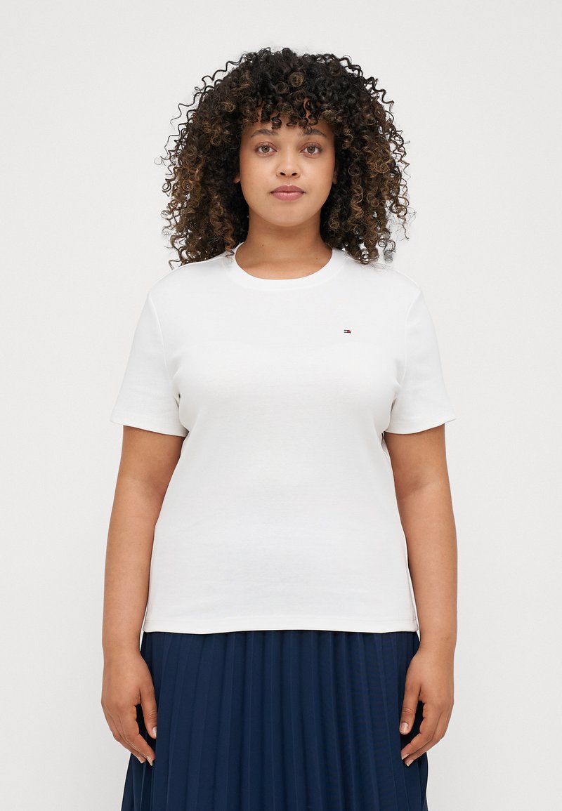 White cotton t-shirt with a crew neck, short sleeves, and a small logo accent on the chest. Smooth texture and regular fit.