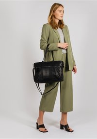 Borsa tote in pelle nera con due manici superiori e una tracolla regolabile, dotata di una tasca frontale con zip e una superficie liscia.
