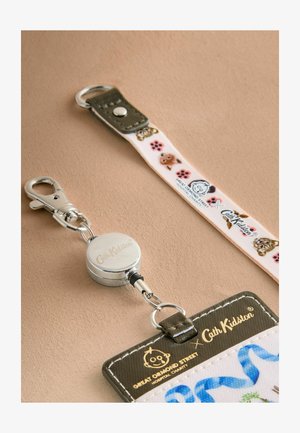 Chowany uchwyt na identyfikator o srebrnym wykończeniu, wyposażony w różowy pasek z wzorem zwierząt oraz brązowy akcent ze skóry.