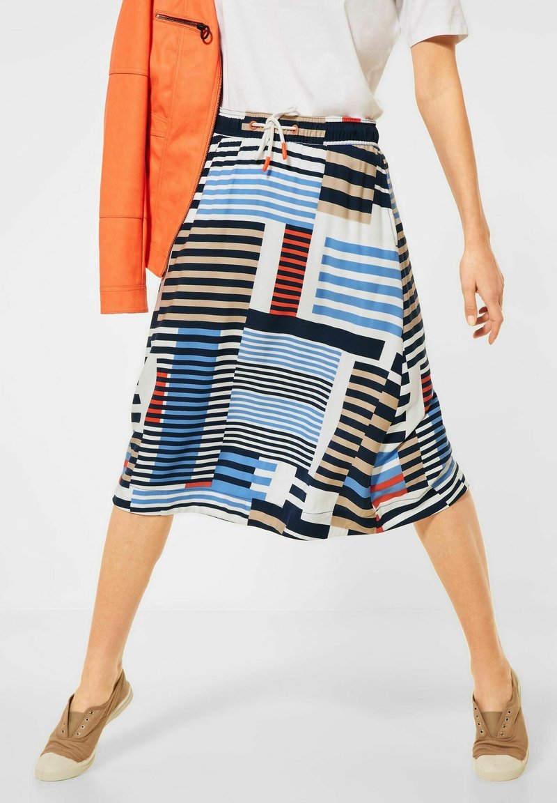 Polvisen pituinen hame, jossa on sekoitus rohkeita geometrisia kuvioita sinisen, punaisen, beigen ja mustan sävyissä, valmistettu kevyestä, sileästä kankaasta.