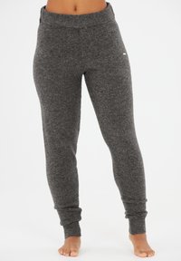 Gray, fitted sweatpants made from a soft, textured fabric. Features a wide, ribbed waistband and tapered cuffs at the ankles.