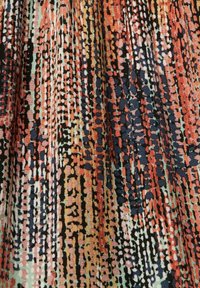 Tissu multicolore présentant un motif de lignes verticales et de points dans des teintes de rouge, noir et bleu clair, avec une finition texturée.