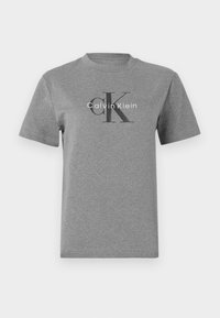 Pilkas medvilnės marškinėliai su apvali apykakle, trumpomis rankovėmis, puikuojantis juodu "CK" logotipu ir balta "Calvin Klein" užrašu.