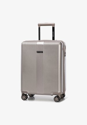 Stříbrný tvrdý kufr s vertikálními drážkami, teleskopickou rukojetí a otáčivými kolečky. Logo značky je viditelně zobrazeno.