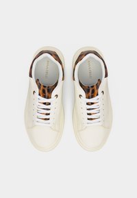 Άσπρα αθλητικά παπούτσια με λευκά κορδόνια, διακοσμημένα με λεπτομέρειες τύπου λεοπάρδαλης στη γλώσσα και τη φτέρνα, σε θέα από πάνω.