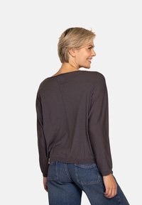 Dunkelgraues Langarmshirt mit weitem Ausschnitt und lockerem Schnitt, mit gesteppten Details auf der Rückseite und gerippten Bündchen.