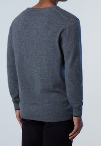 Szary sweter dzianinowy z długimi rękawami, okrągłym dekoltem, prążkowanymi mankietami i ściągaczem u dołu. Miękka faktura, lekko luźny krój, gładki, bez wzorów i ozdób.