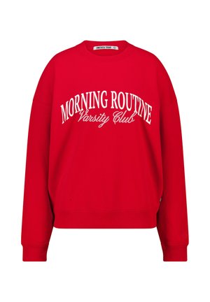 Red sweatshirt made of cotton, featuring a crew neckline and ribbed cuffs. "MORNING ROUTINE Varsity Club" printed in bold white lettering.
