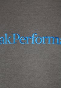 Tissu gris avec le texte brodé en bleu "PeakPerformance", présentant une texture lisse et uniforme sans motifs ni accents visibles.
