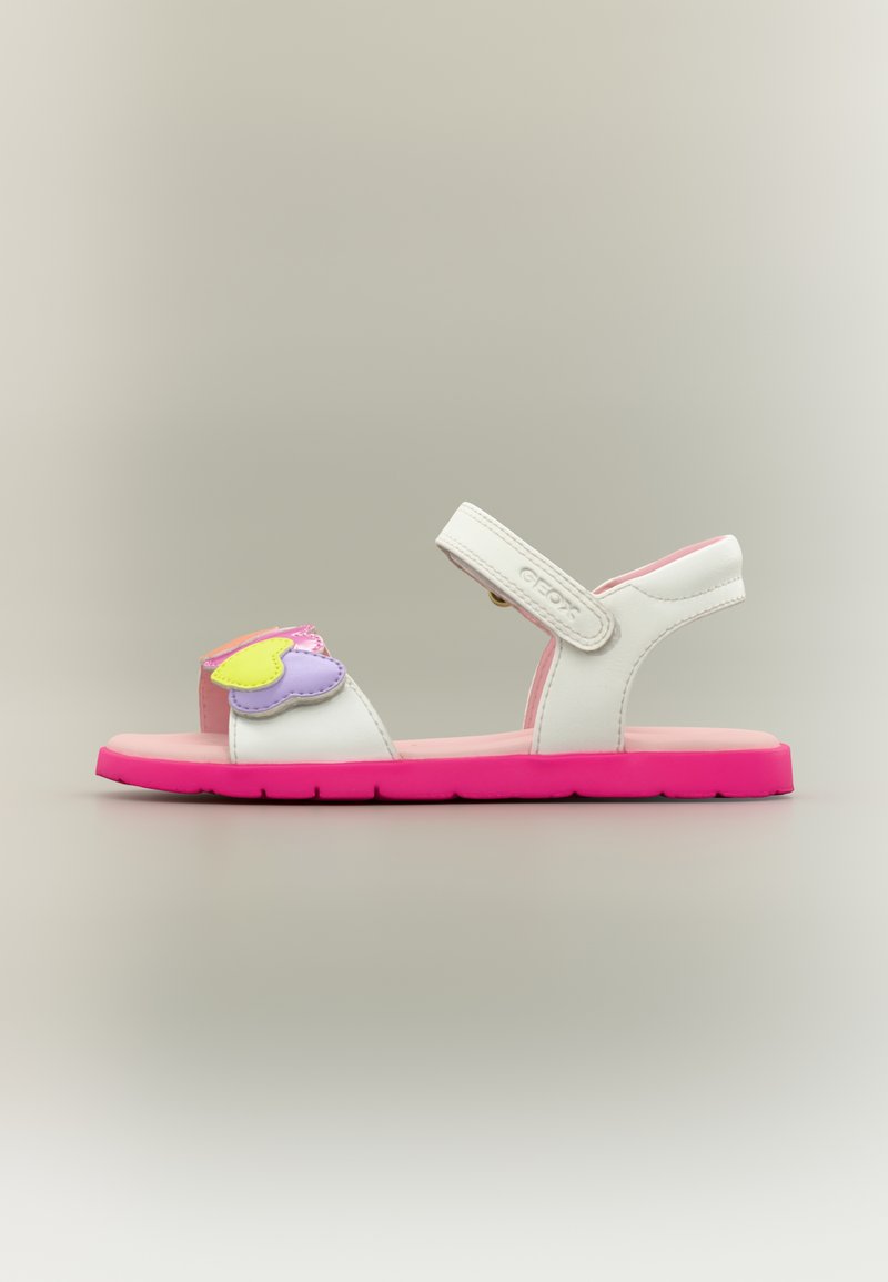 Άσπρο και ροζ παιδικό σανδάλι με λουράκι Velcro, διακοσμημένο με κίτρινες και μοβ καρδιές στο μπροστινό λουράκι.