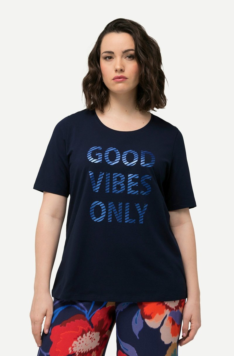 Camiseta de color azul marino con el texto "SOLO BUENAS VIBRAS" en letras azules a rayas. Mangas cortas, cuello redondeado, tela suave.