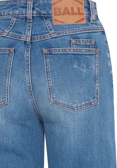 Modré rifľové nohavice s kontrastným oranžovým prešitím a hnedou koženou nášivkou s nápisom "BALL." Majú dve zadné vrecká a rovný strih.