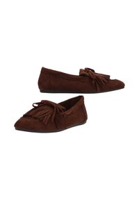 Mocasin de ante marrón con punta afilada, detalle de flecos y un pequeño lazo como acento. El material texturizado ofrece una apariencia suave.