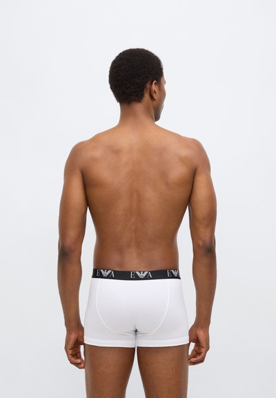 Λευκά βαμβακερά σλιπ boxer με μαύρη ζώνη μέσης που φέρει το λογότυπο "EVA." Απλός σχεδιασμός, εφαρμοστό σχήμα, απαλή υφή και χωρίς σχέδια.