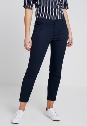 Granatowe spodnie dopasowane, wykonane z rozciągliwego materiału. Posiadają szlufki na pasek, zapięcie na guzik oraz subtelne detale w przeszyciach.