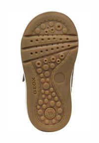 Semelle de chaussure en caoutchouc brun présentant une variété de motifs de semelle circulaires et ovales, avec le texte "SYSTÈME FLEXY" et "SOUPLEMENT REMBOURRÉ" visible.