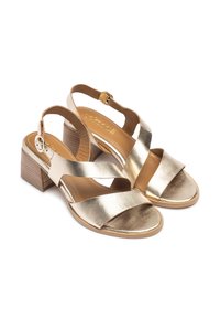 Sandali in pelle metallizzati dorati con cinturini incrociati, punta aperta e tacco a blocco. Presentano una chiusura con fibbia e una texture liscia.