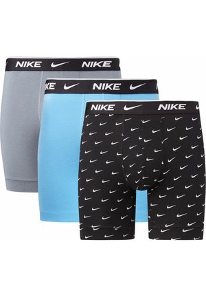 Drei Paar Nike Boxer-Shorts: grau, hellblau und schwarz mit weißen Swoosh-Mustern. Die elastischen Taillenbünde sind mit auffälligem Nike-Branding versehen.
