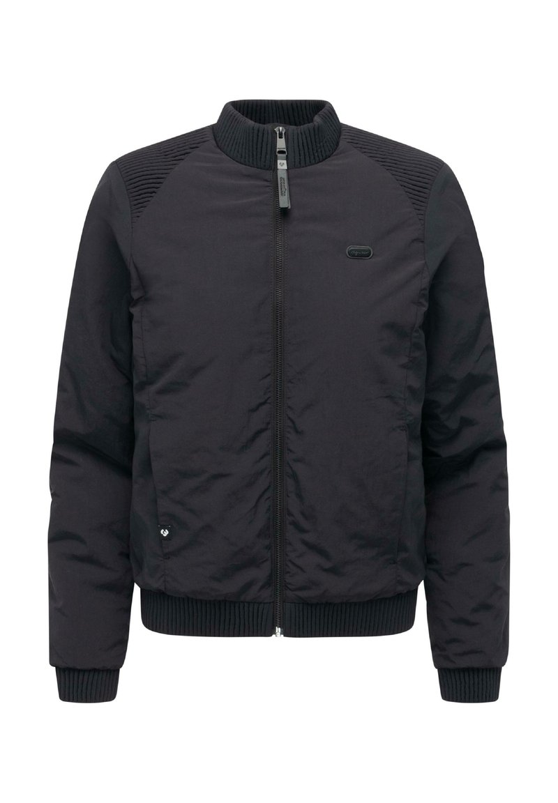 Czarna kurtka typu bomber z prążkowanym kołnierzem i mankietami. Charakteryzuje się pikowanymi akcentami na ramionach i centralnym zapięciem na zamek błyskawiczny. Gładka, syntetyczna tekstura.