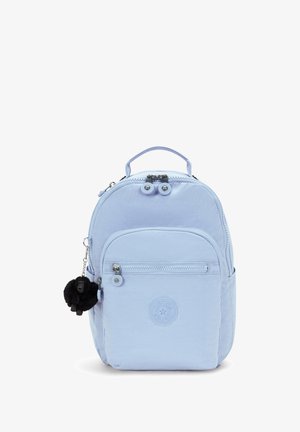 Sac à dos bleu clair avec double fermeture éclair, poche avant et logo circulaire. Le tissu texturé est agrémenté d'un charme en fourrure noire attaché à une fermeture éclair.