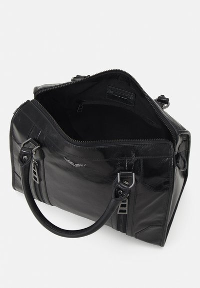 Sac à main en cuir noir avec fermeture éclair, double poignées et deux poches latérales zippées. Intérieur doublé en tissu, détails matériels minimaux.