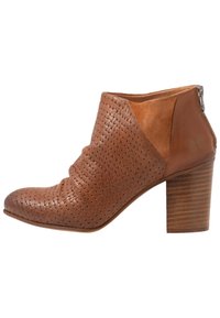 Bottine en cuir marron avec texture tissée, bout pointu et talon en bois empilé. Elle dispose d'une fermeture éclair sur le côté et d'un panneau lisse.