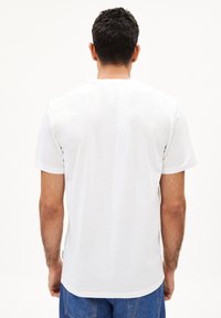 Weißes Baumwoll-T-Shirt mit Rundhalsausschnitt und kurzen Ärmeln, mit einem schlichten Rückendesign und gerader Saumlinie.