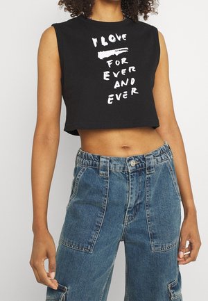 Zwarte cropped tanktop met witte tekst "IK HOUD VOOR EEUWIG EN EEUWIG." Katoenen materiaal, mouwloos ontwerp en een relaxte pasvorm. Blauwe denim cargo broek.