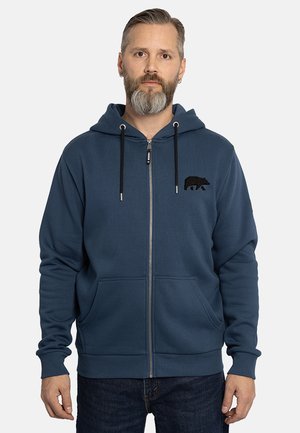 Blauwe ritsshirt hoodie van zacht materiaal, met een berenlogo op de borst, een verstelbare capuchon en twee voorzakken.