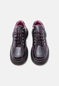 Μαύρα παπούτσια πλατφόρμας από δερμάτινο βινύλιο με ροζ ραφές, ροζ και μαύρα κορδόνια και ροζ εσωτερική επένδυση, σε λευκό φόντο, φωτογραφημένα από επάνω.