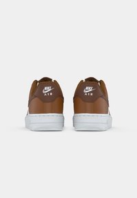 Rudi od anilinės odos Nike Air sportbačiai su baltais padais. Savybės: paminkštinta apykaklė, balta logo ant kulno ir siuvinėtos detalės.