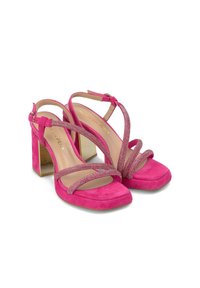 Różowe zamszowe sandały na słupku z krzyżującymi się paskami i błyszczącymi akcentami. Kwadratowy fason noska z obcasem w złotym kolorze.