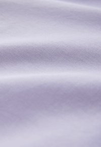 Šviesiai violetinė medžiaga su lygiu, šiek tiek tekstūruotu paviršiumi ir švelniais raukšlėmis, kurios kuria minkštas bangas.