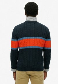 Navy gebreid sweater met kabelpatroon, voorzien van horizontale strepen in oranje en lichtblauw over de rug, en een geribbelde kraag.