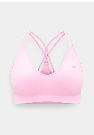 Brassière de sport rose clair avec fines bretelles doubles croisées et un petit logo réfléchissant sur le côté droit avant.