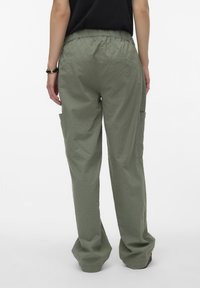 Groene cargo broeken met een textuurafwerking, elastische tailleband en zijzakken, weergegeven vanuit de achterkant tegen een witte achtergrond.