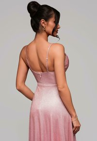 Rosa, glittrande aftonklänning med tunna remmar och en figurnära överdel, med dragkedjestängning i ryggen och en flödande kjol.