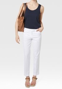 Marineblauw mouwloos topje, witte op maat gemaakte broek, bruin leren tote bag en gestreepte wedge sandalen. Minimalistisch ontwerp met strakke lijnen.