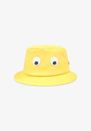 Cappello a secchiello giallo realizzato in tessuto liscio, con due grandi occhioni di plastica nella parte anteriore e una visiera larga e curva.