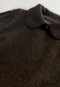Brown wool sweater with a ribbed texture and a dark leather collar. Features a button closure at the collar and soft, fuzzy material.